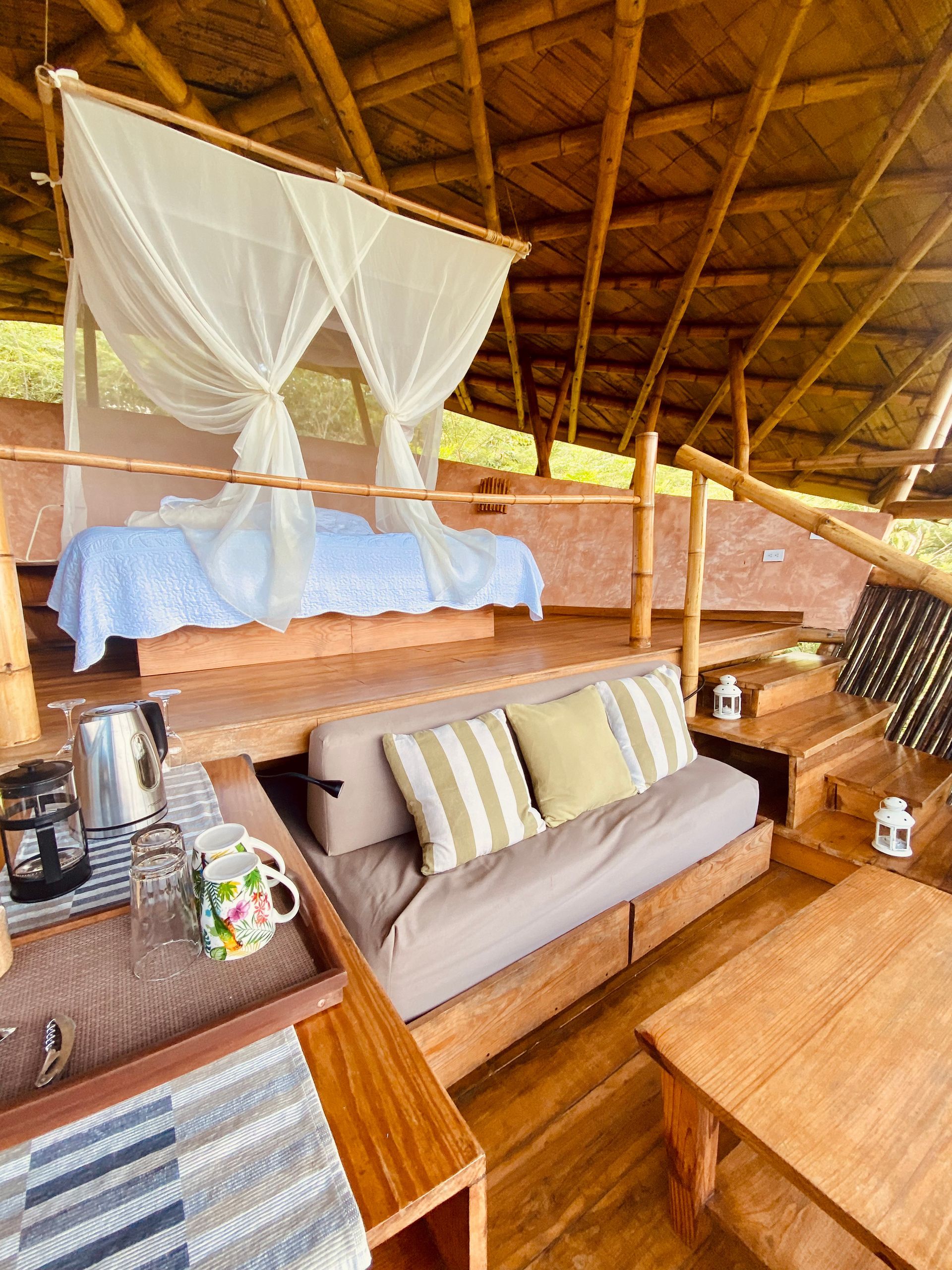 A living room with a couch , table , and canopy bed.