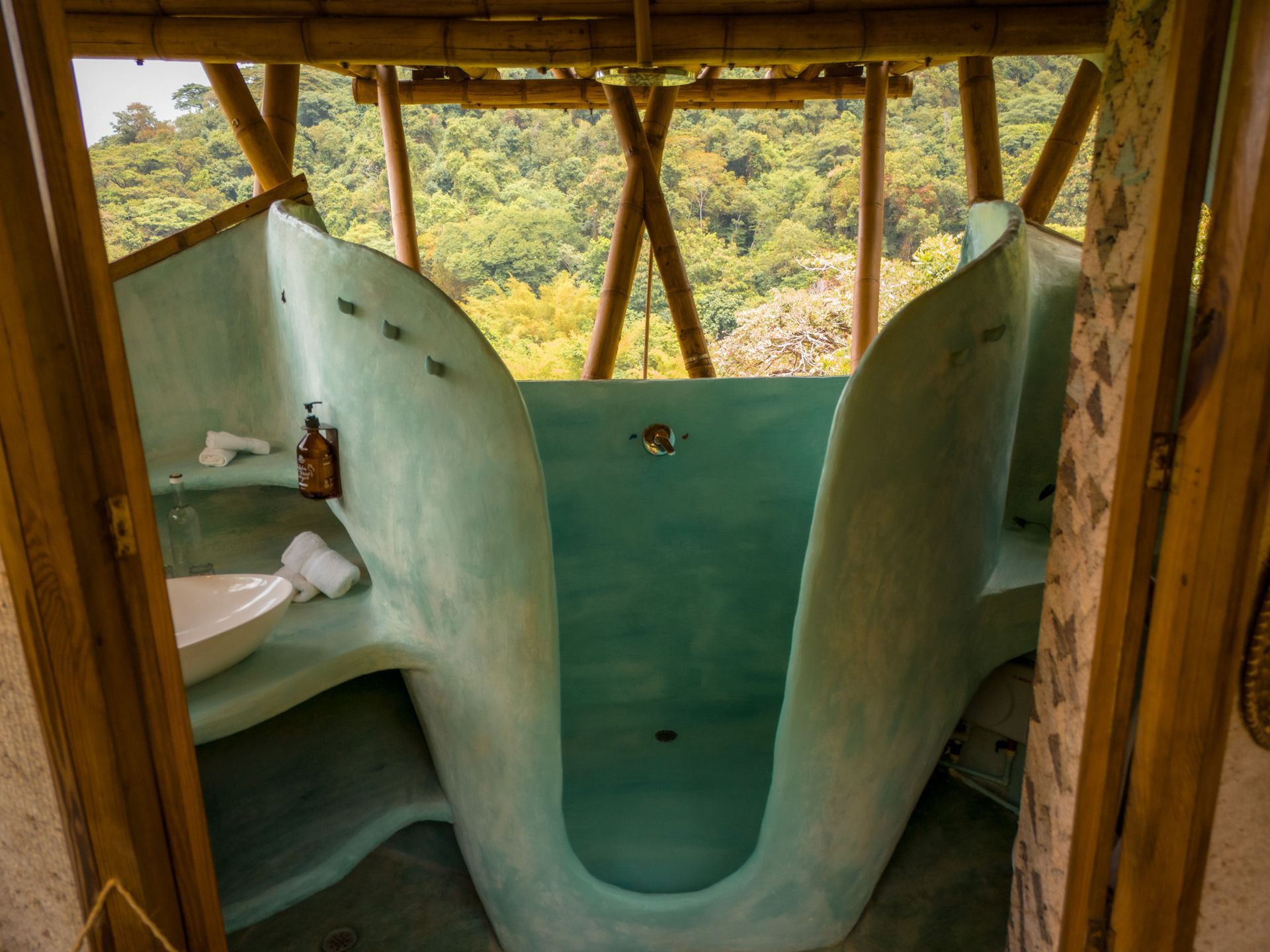 A bathroom with a large blue tub and a sink