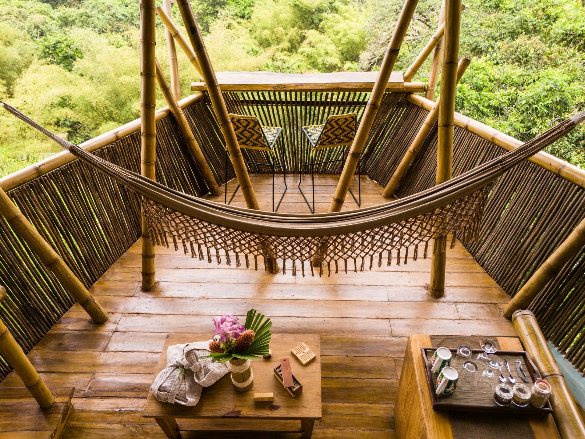 A wooden deck with a hammock and a table.