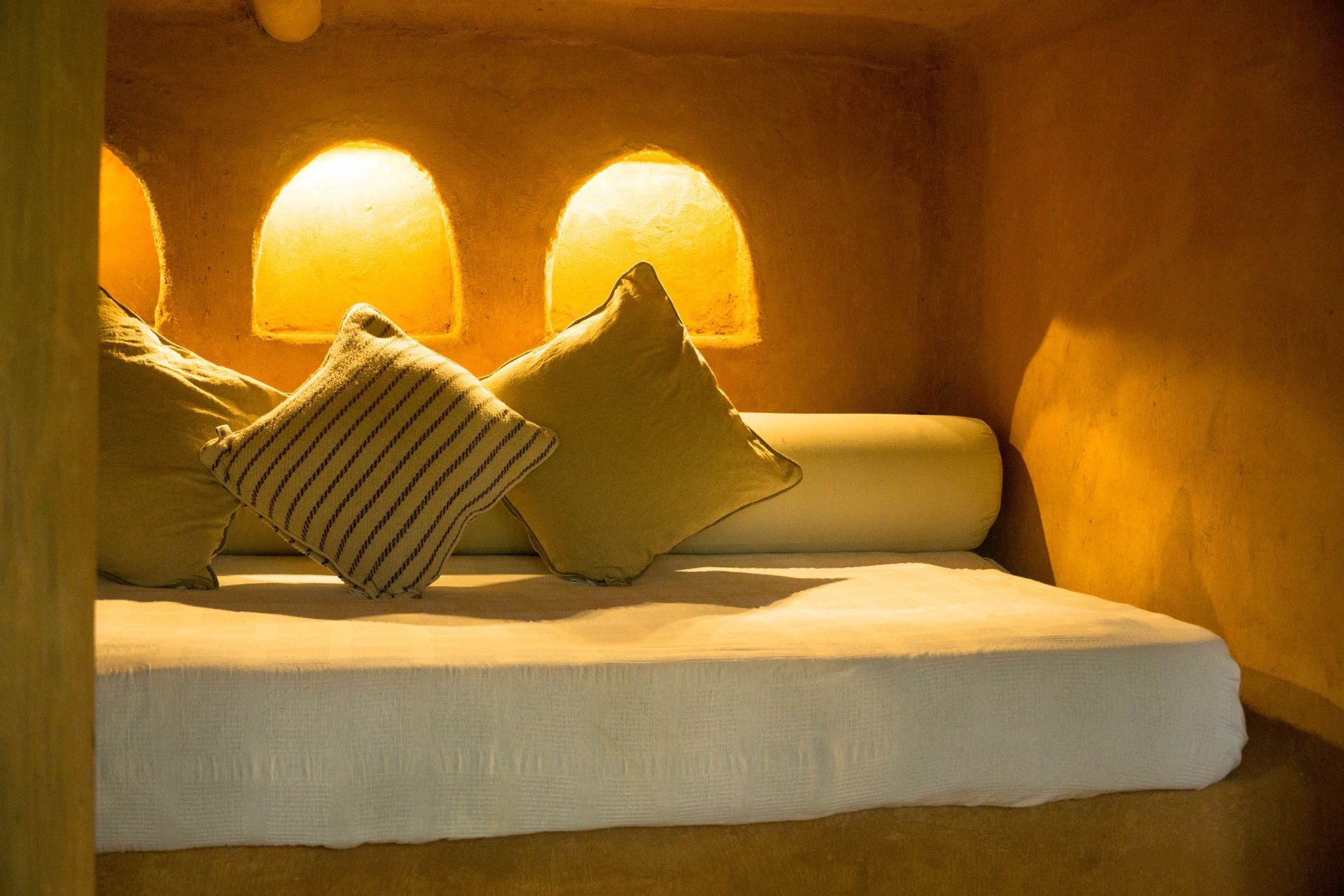 A bed with pillows and lamps in a room.