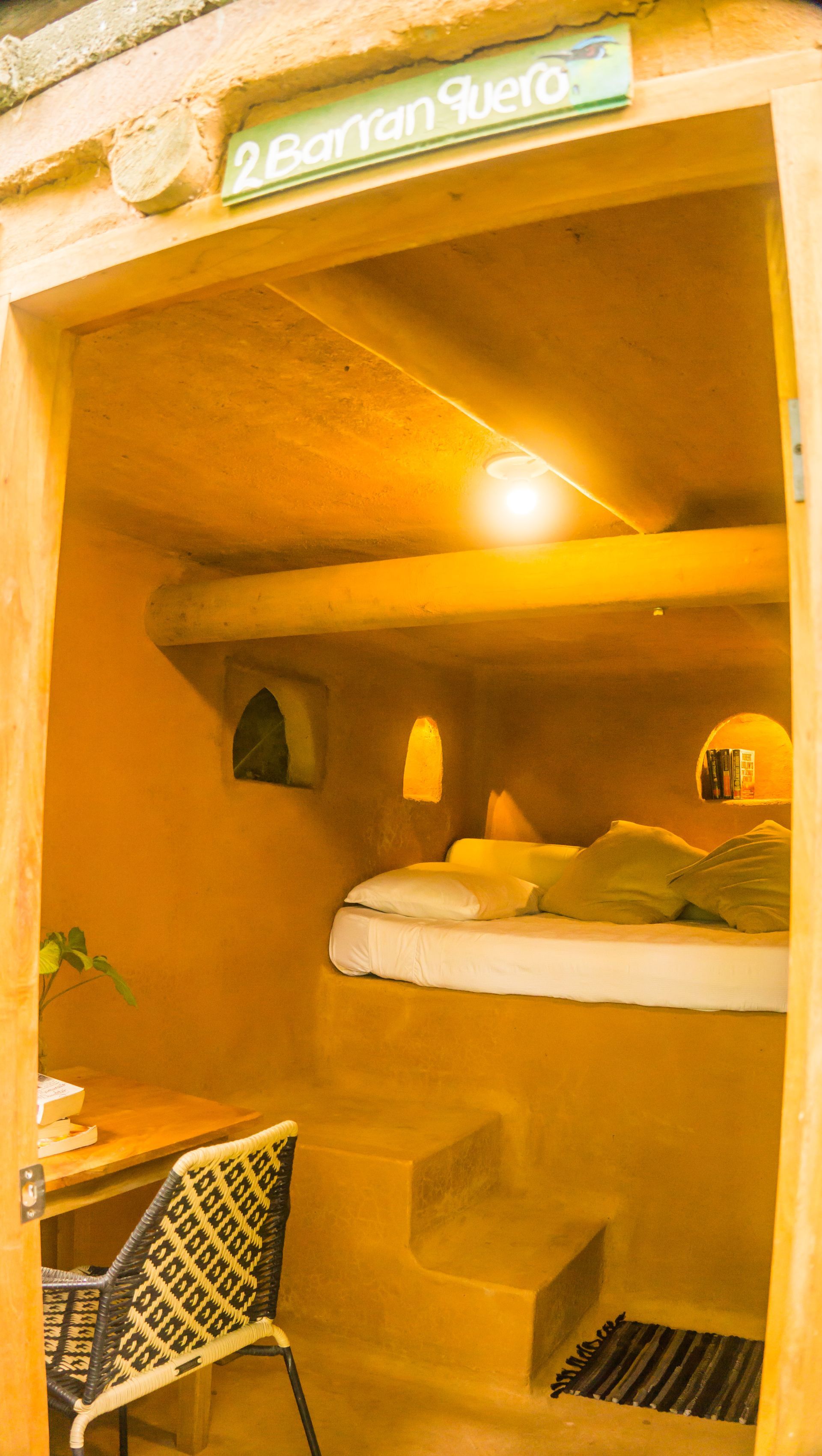 A small room with a bed , table and chairs in it.