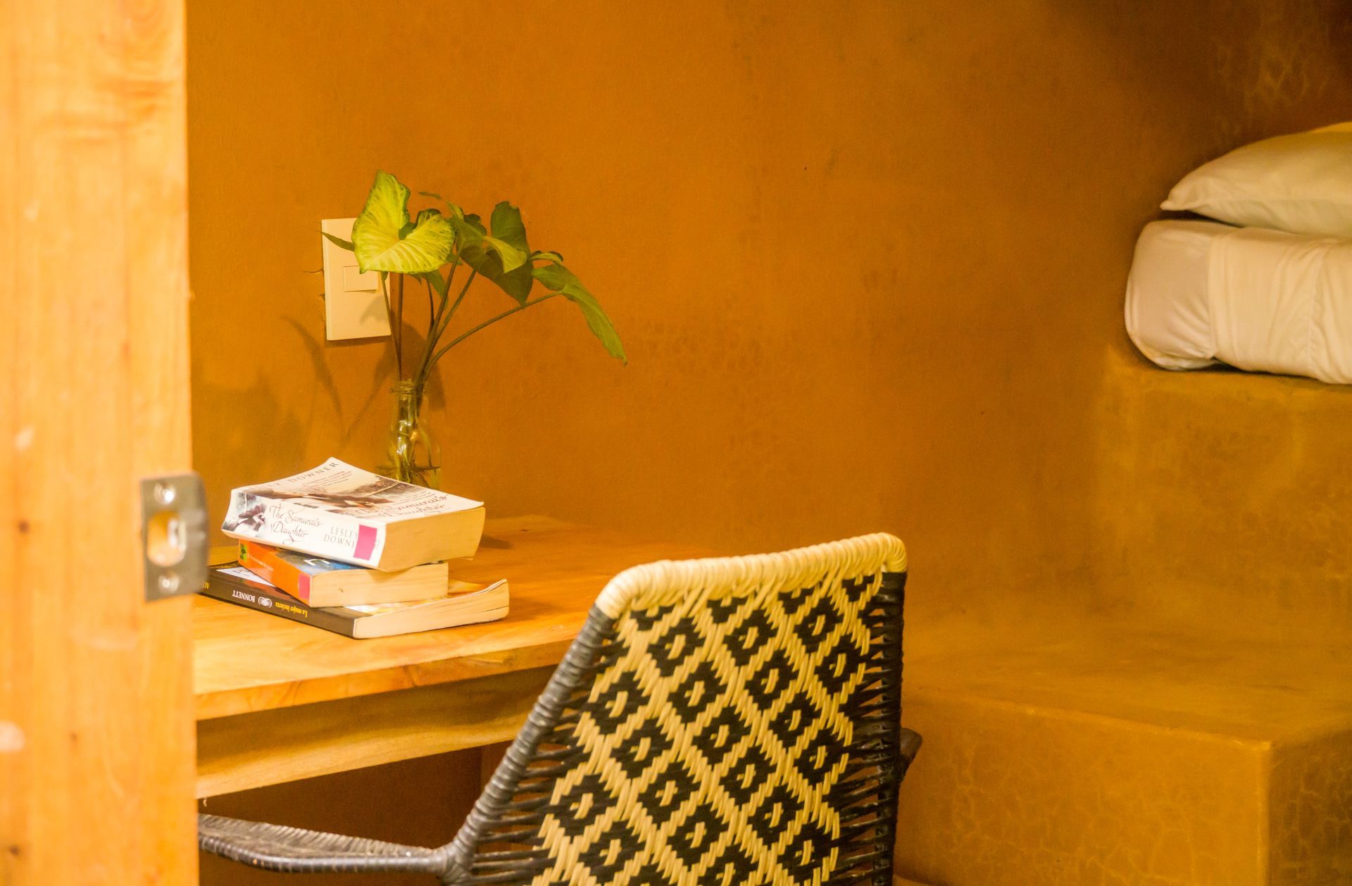 A chair is sitting in front of a desk with books on it.