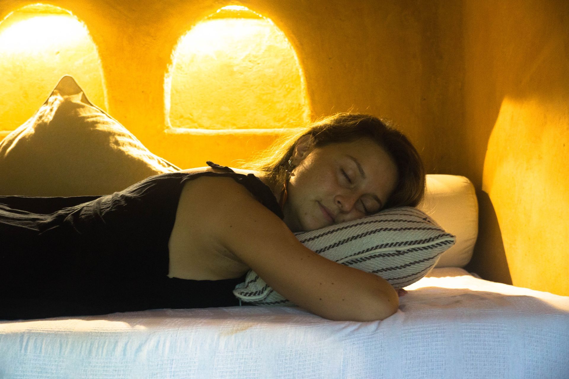 A woman is sleeping on a bed with a pillow.