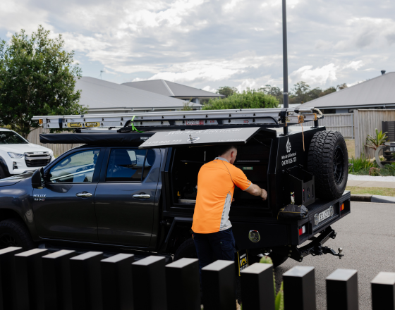 Win Air & Electrical team member retrieving equipment from work ute.