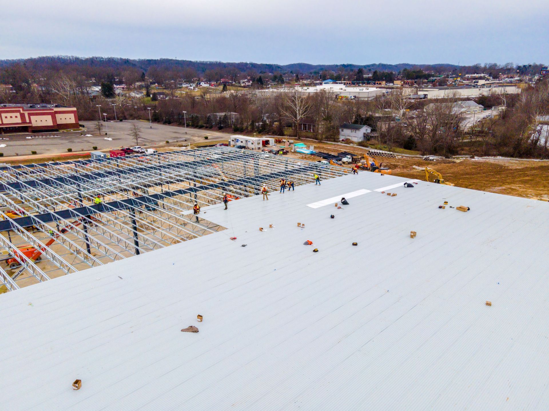 Snow-covered rooftop with HVAC units and a distant industrial landscape beyond.