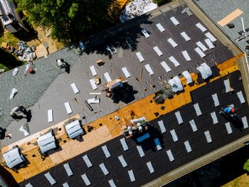 Aerial view of a crosswalk with pedestrians, cars, and orange traffic barriers on a city street.