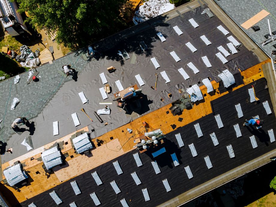 Aerial view of a city intersection with cars, a yellow crosswalk, and pedestrians crossing the street