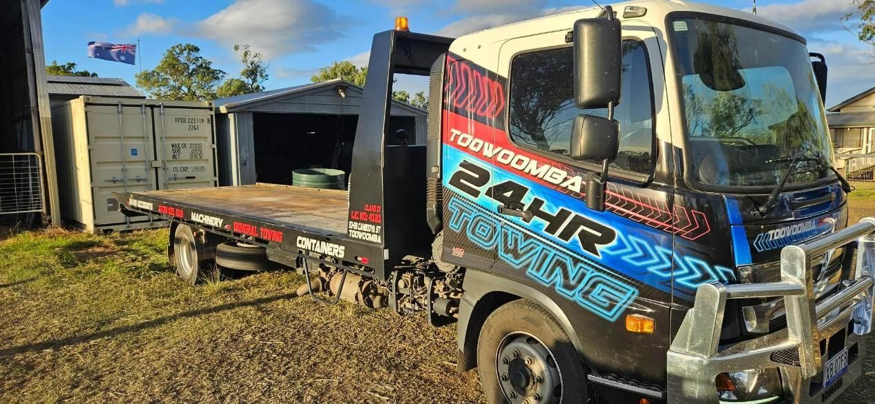 Tow Truck With a Flat Bed is Parked in a Gravel Lot — Toowoomba 24hr Towing In Toowoomba, QLD