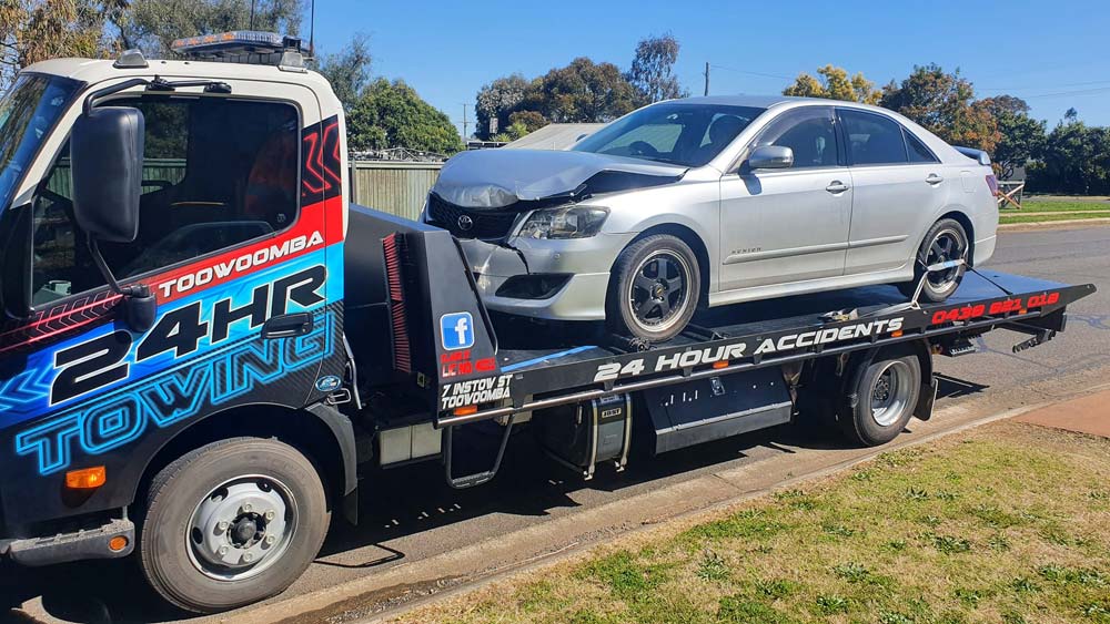 Wrecked Car After An Accident On A Tow Truck Transported On A Highway — Toowoomba 24hr Towing In Toowoomba, QLD