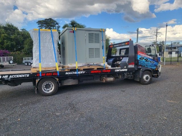 A Tow Truck is Carrying a Container on The Back of it — Toowoomba 24hr Towing In Toowoomba QLD