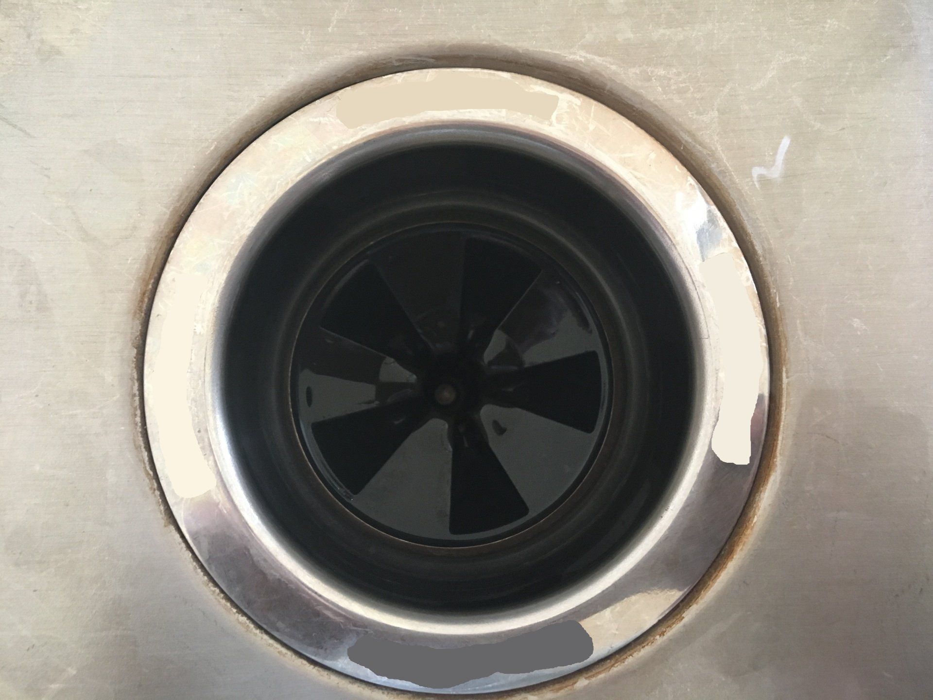 A close up of a stainless steel sink drain