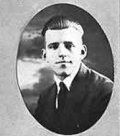 A black-and-white portrait of a person in a suit and tie, presented in an oval frame.