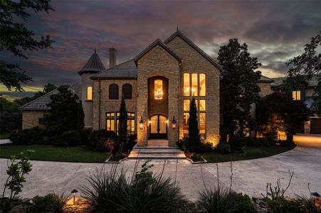 Brick house with a large green backyard and a tree in front