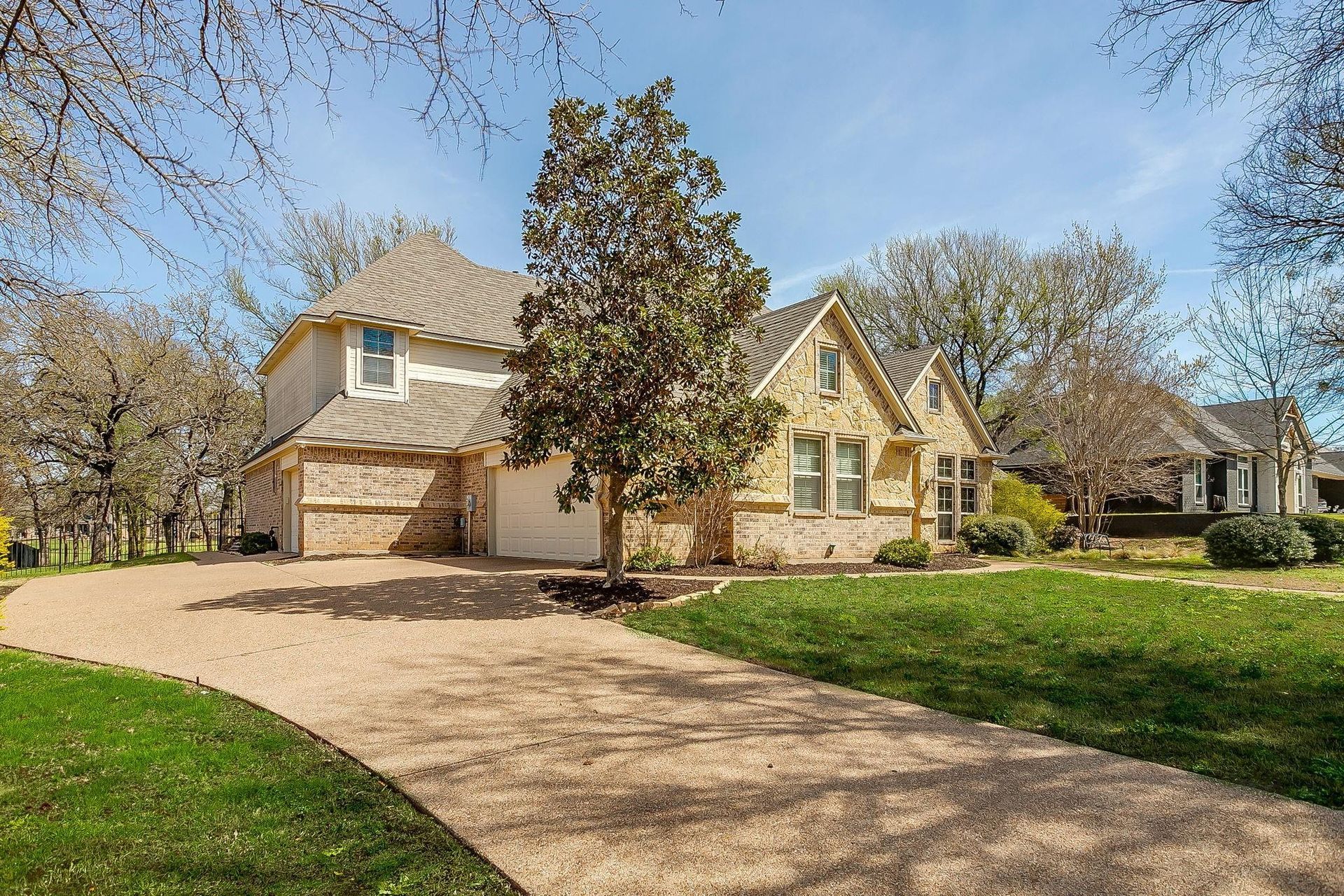 Brick suburban house entrance with arched windows, front garden, and a glass front door