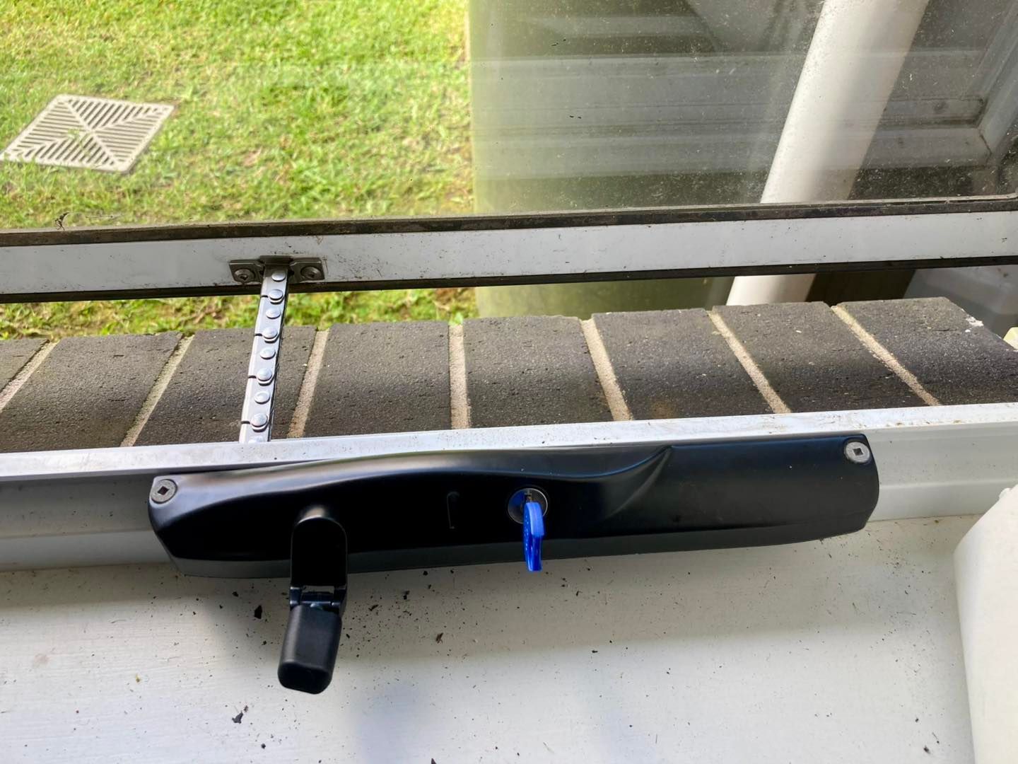 Black Gutter Cleaning Tool With a Blue Key and Black Handle, Near a Window — Fix-A-Door in Morisset, NSW