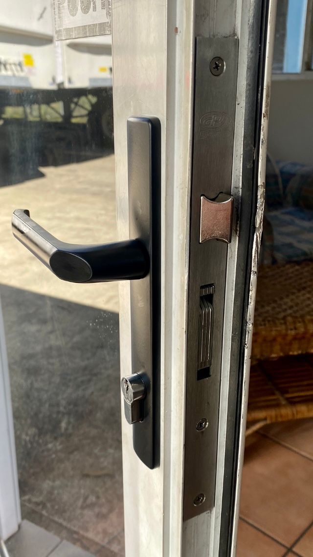 Black door handle and lock on a white door frame; exterior view with sunlight-Fix-A-Door in Morisset, NSW