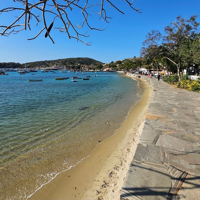 Uma praia com barcos na água em um dia ensolarado