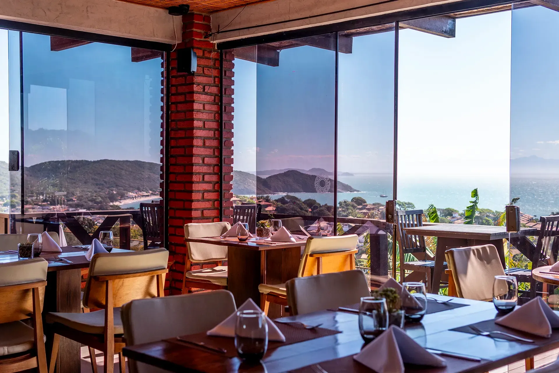 Um restaurante com mesas e cadeiras e vista para o oceano