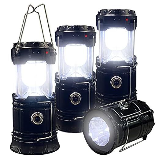 Four black LED camping lanterns glowing bright white, one lying on its side.