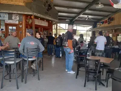 People seated at tables in a casual indoor café or bar with exposed ceiling beams.