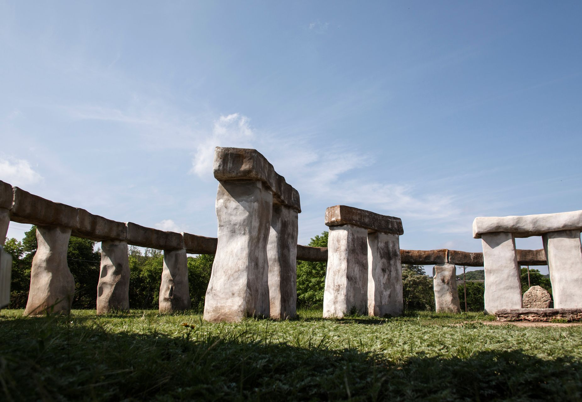 Stonehenge stone circle under a blue sky with green grass in the foreground