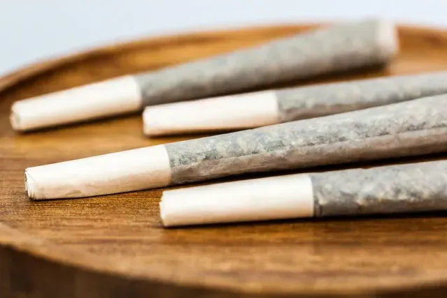 A group of cigarettes are sitting on top of a wooden tray.