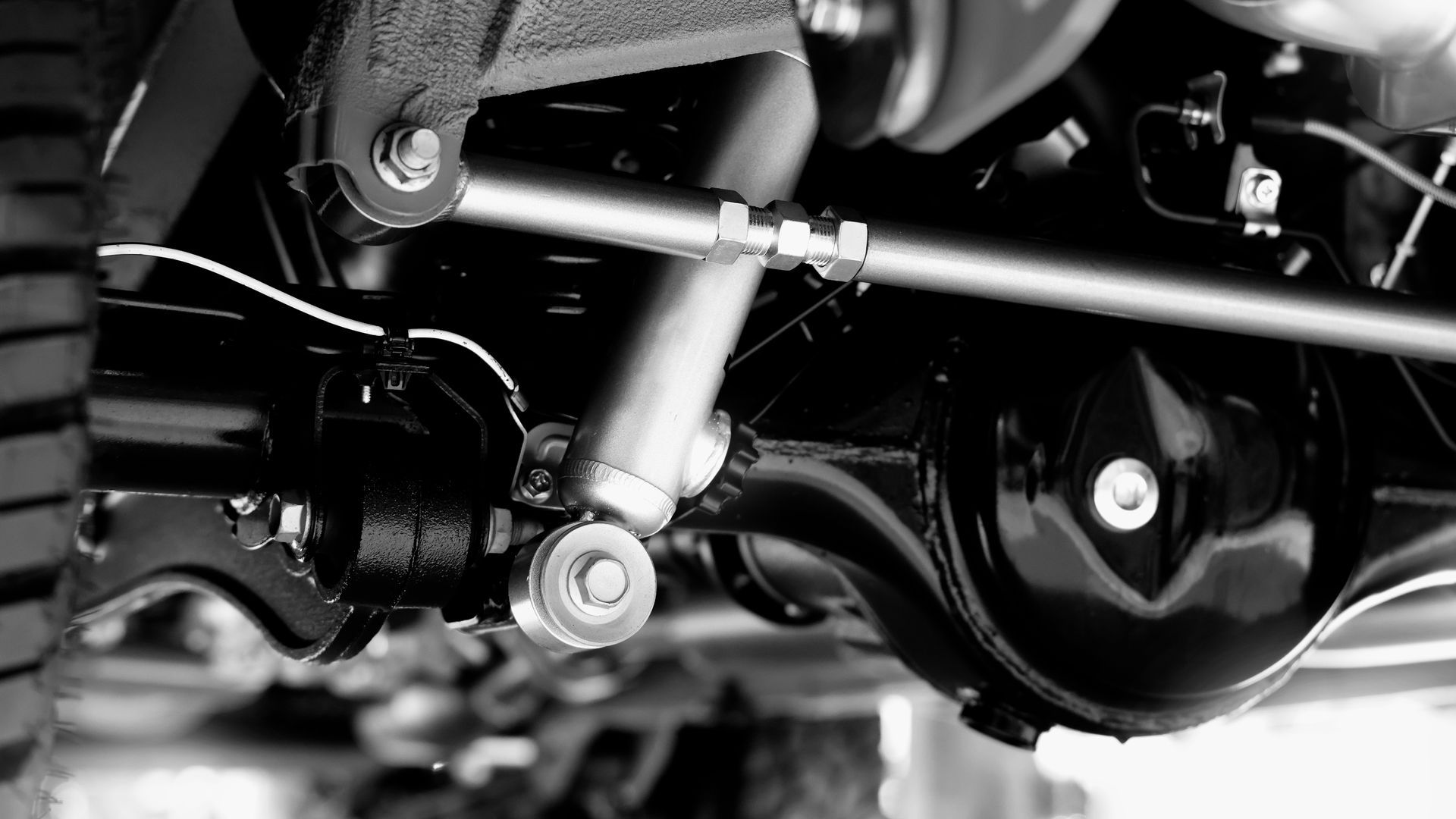 Close-up of a motorcycle’s suspension and engine components in black and silver.
