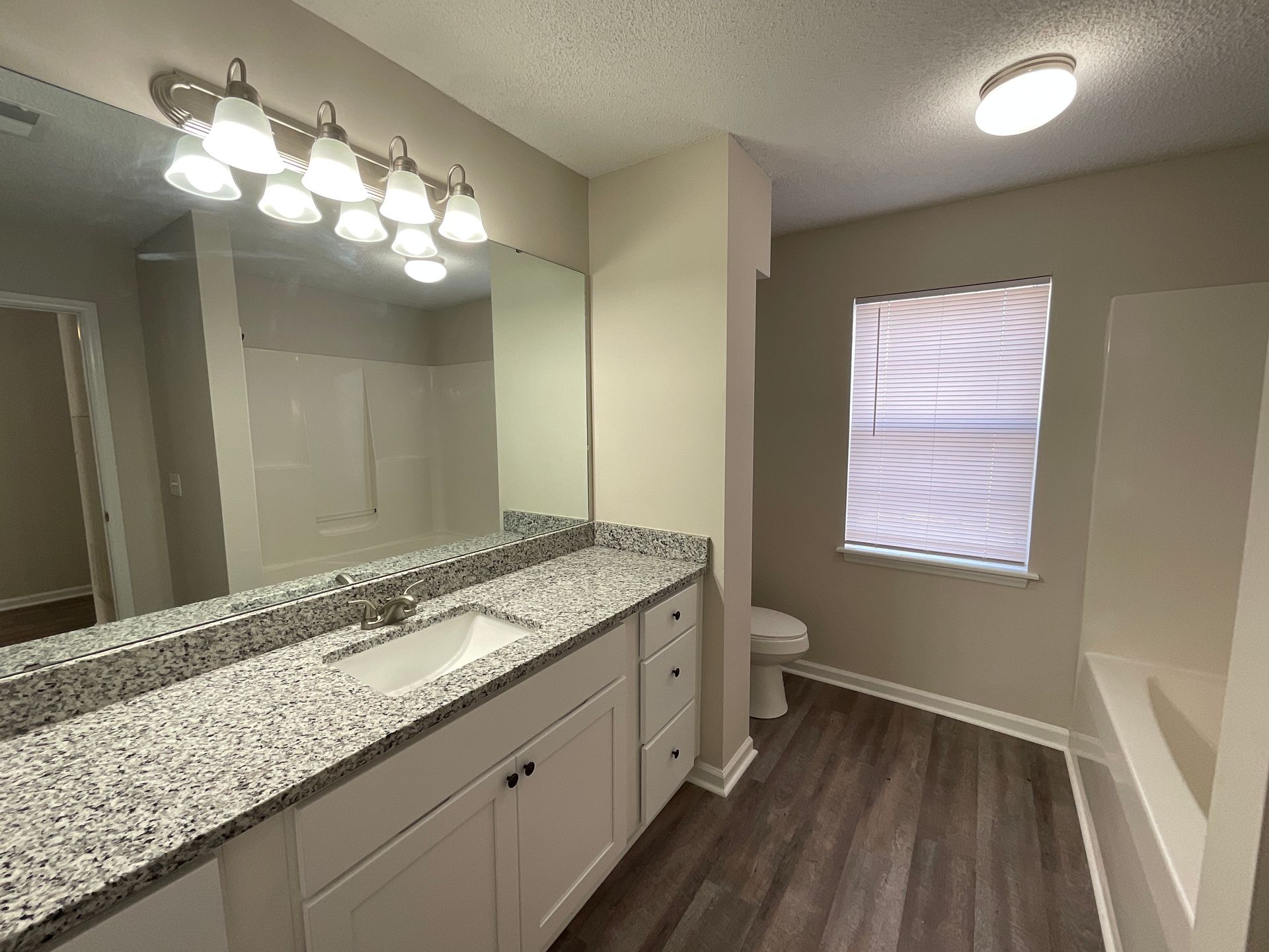 Crest bathroom of the sink, toilet, window, and a little bit of the tub