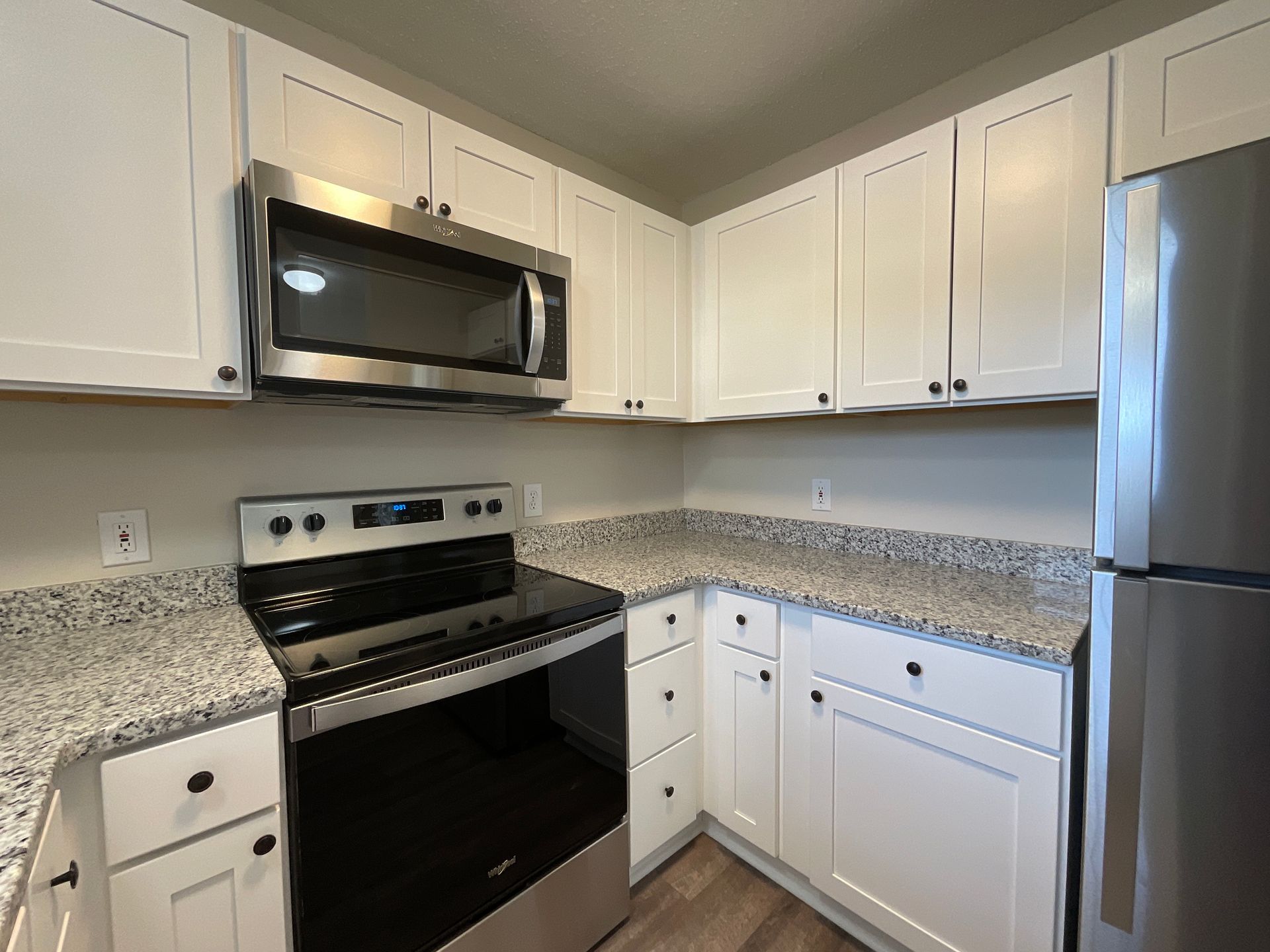 remodeled crest kitchen with all white cabinets with stainless steel microwave, stove, and fridge