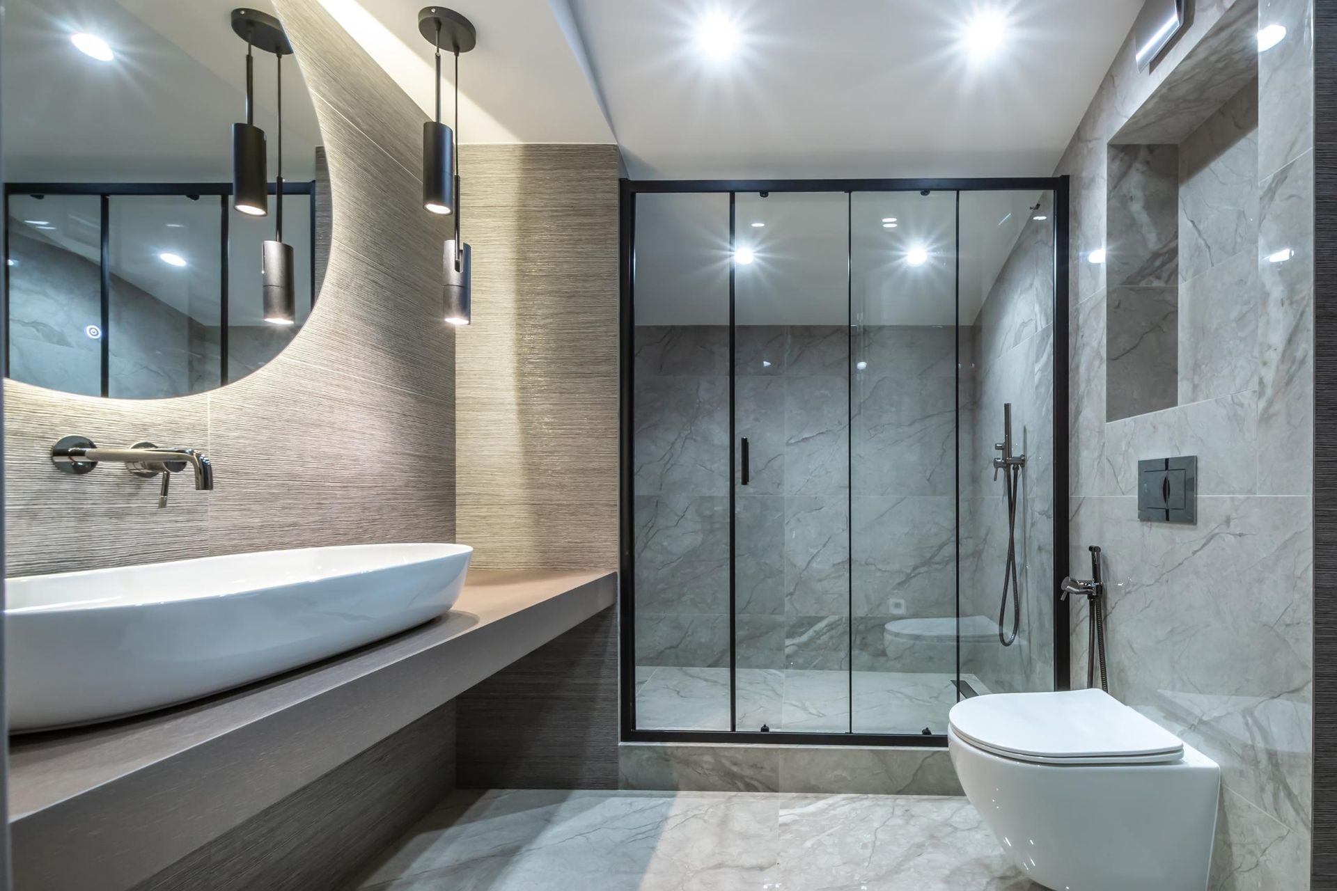 Modern bathroom with floating vanity, vessel sink, glass shower, and wall-mounted toilet