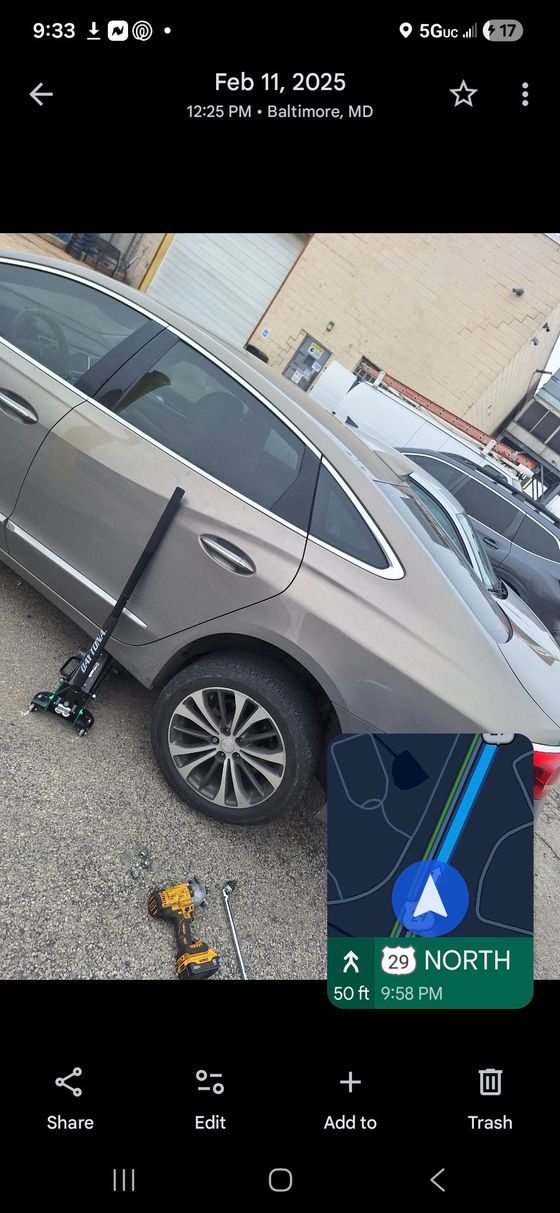 A car lifted on a jack during roadside repair service.