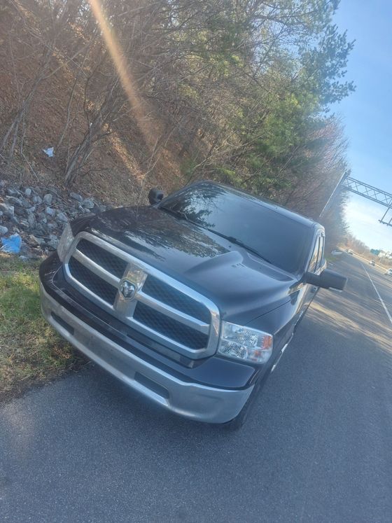A smoking car engine with the hood open during a roadside breakdown.