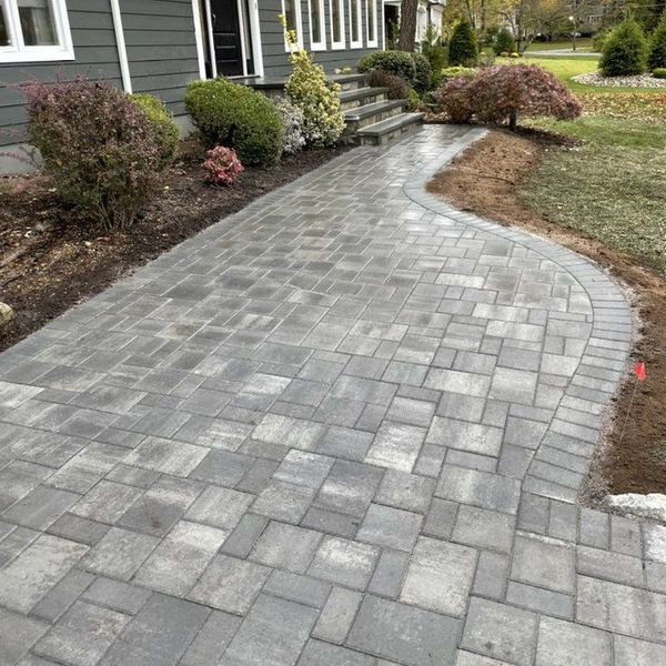 Paver walkway leading to the front of a house.