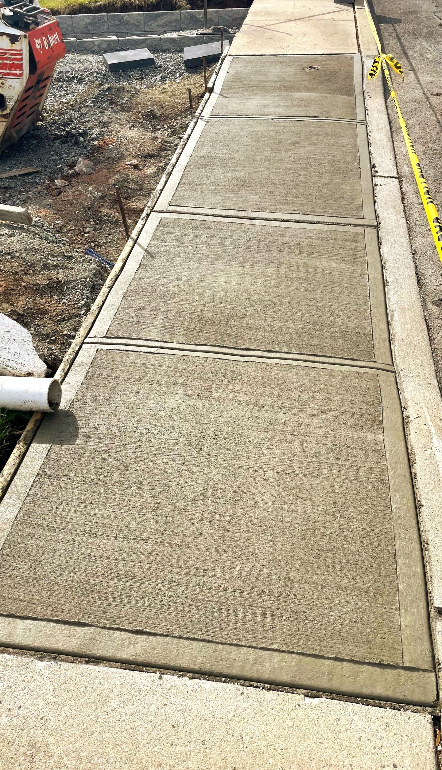 A concrete sidewalk is being built next to a road.