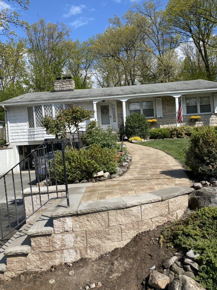 A house with steps and a stone walkway leading to it.