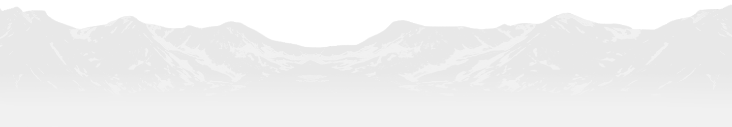Snow-covered mountain range under a pale sky