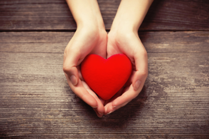 This is a picture of a heart being cupped by two hands.