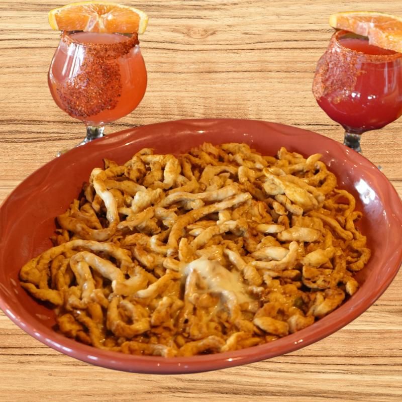 Plate of crispy fried food with two orange cocktails on a wooden table