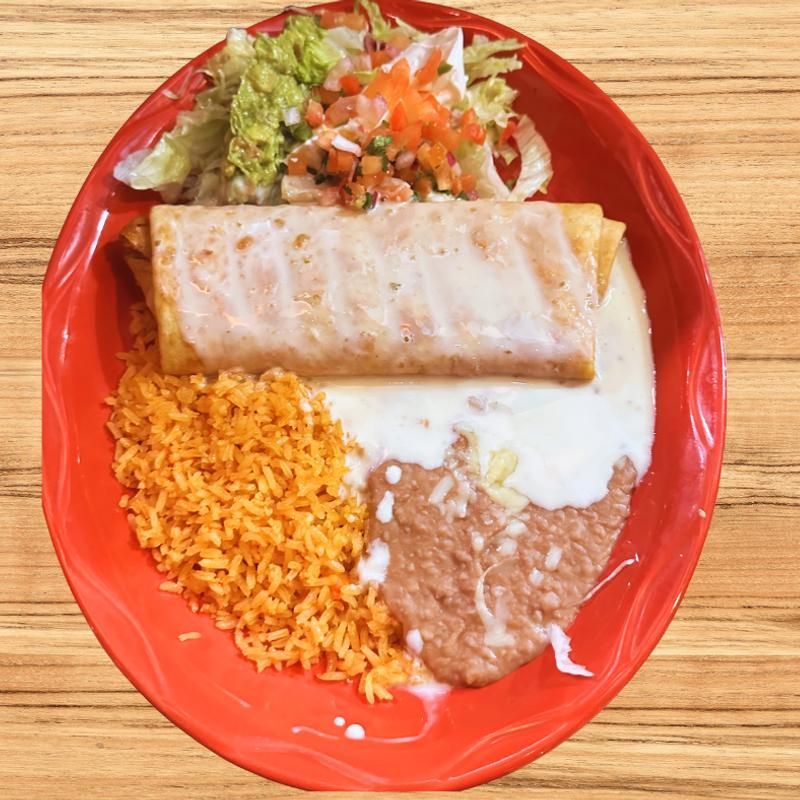 Red plate with a burrito, rice, refried beans, and a small salad on a wooden table