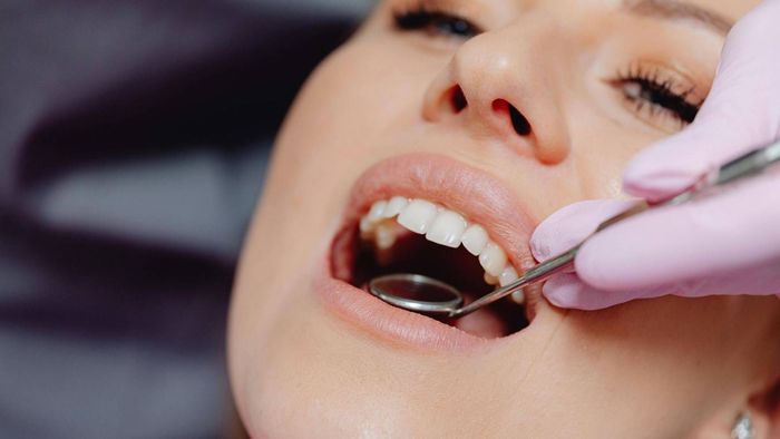 Una mujer se hace examinar los dientes por un dentista.