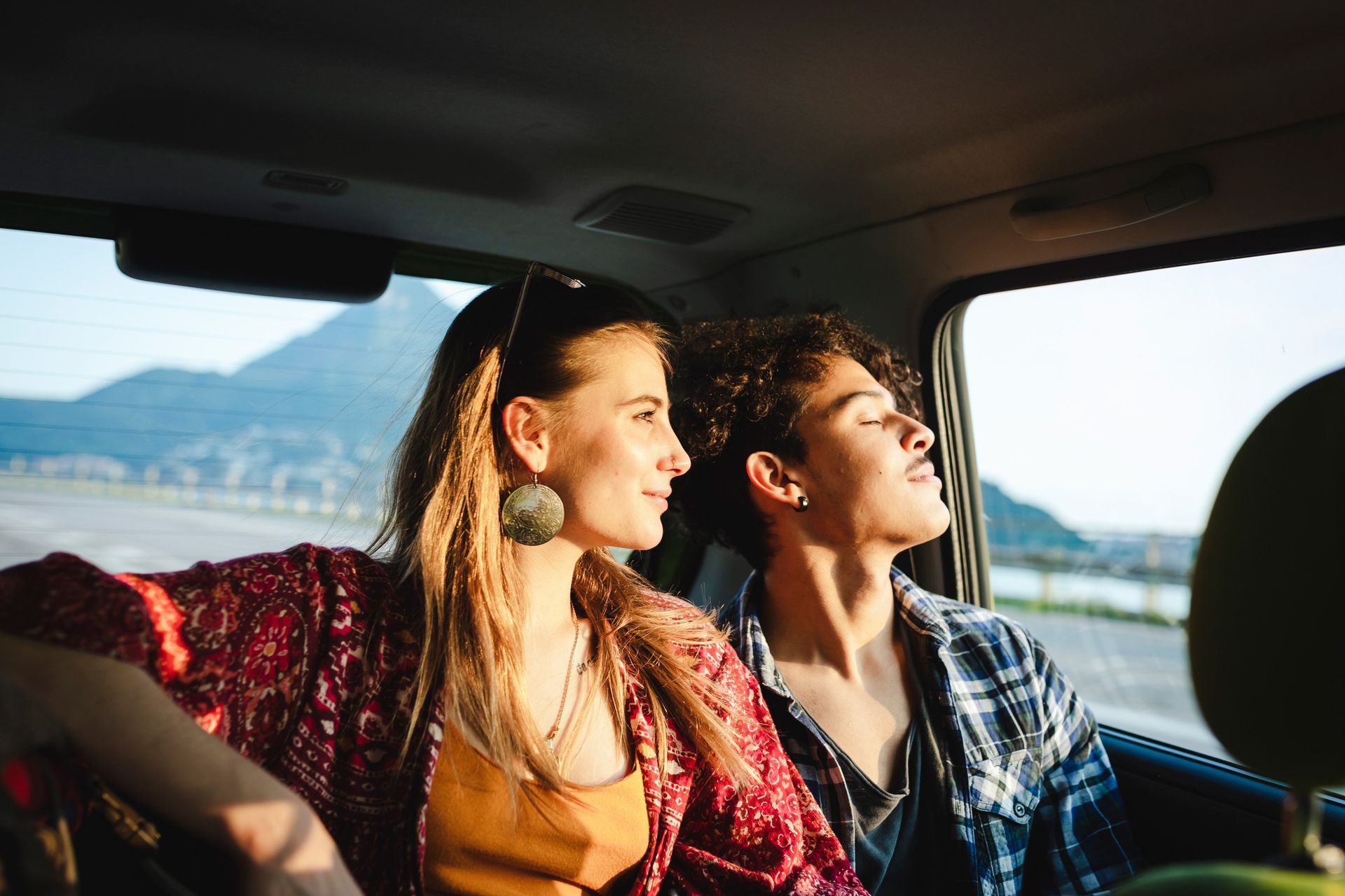 A man and a woman are sitting in the back seat of a car. A man and a woman are sitting in the back seat of a car.