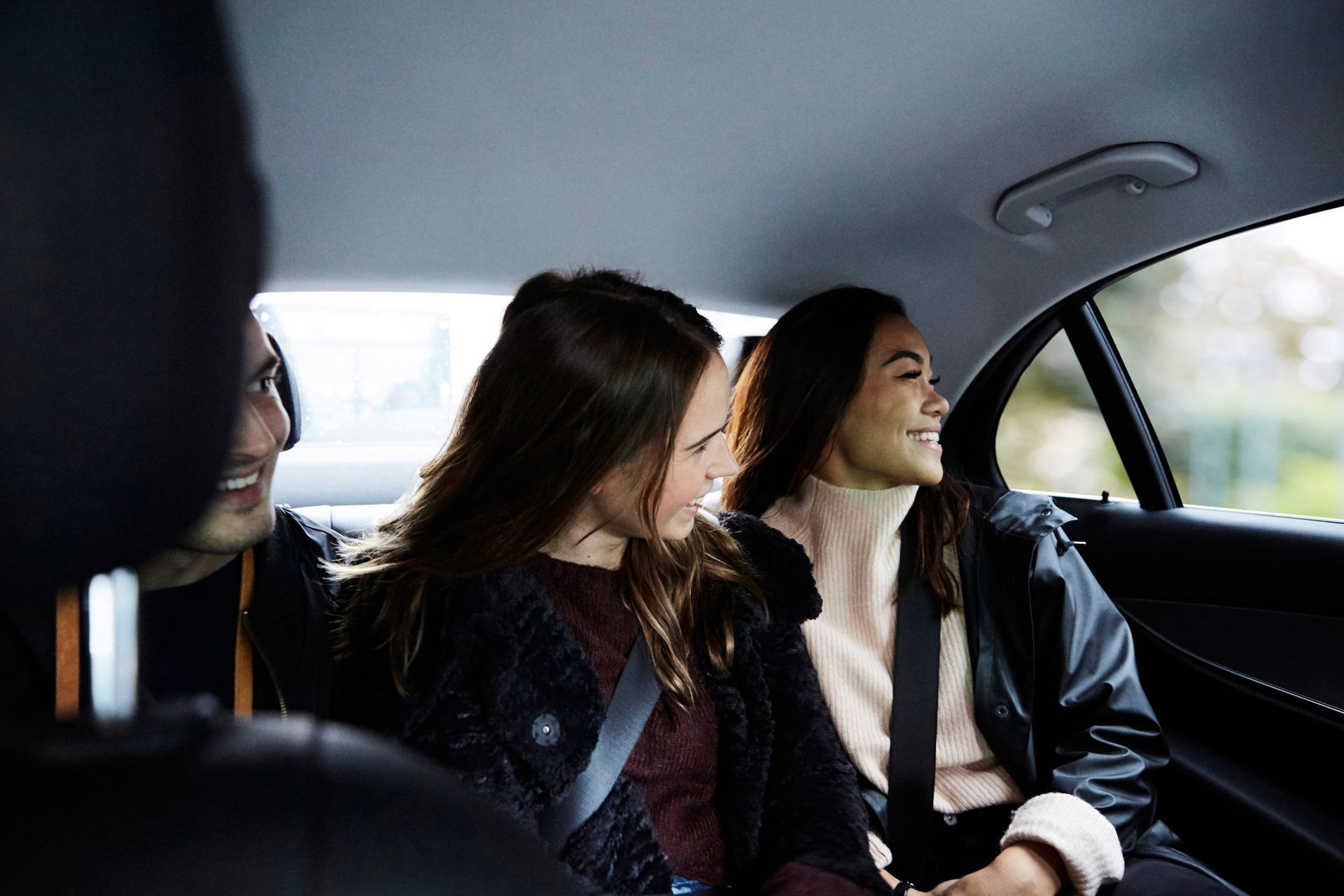 Smiling friends traveling in car at city. Smiling friends traveling in car at city.