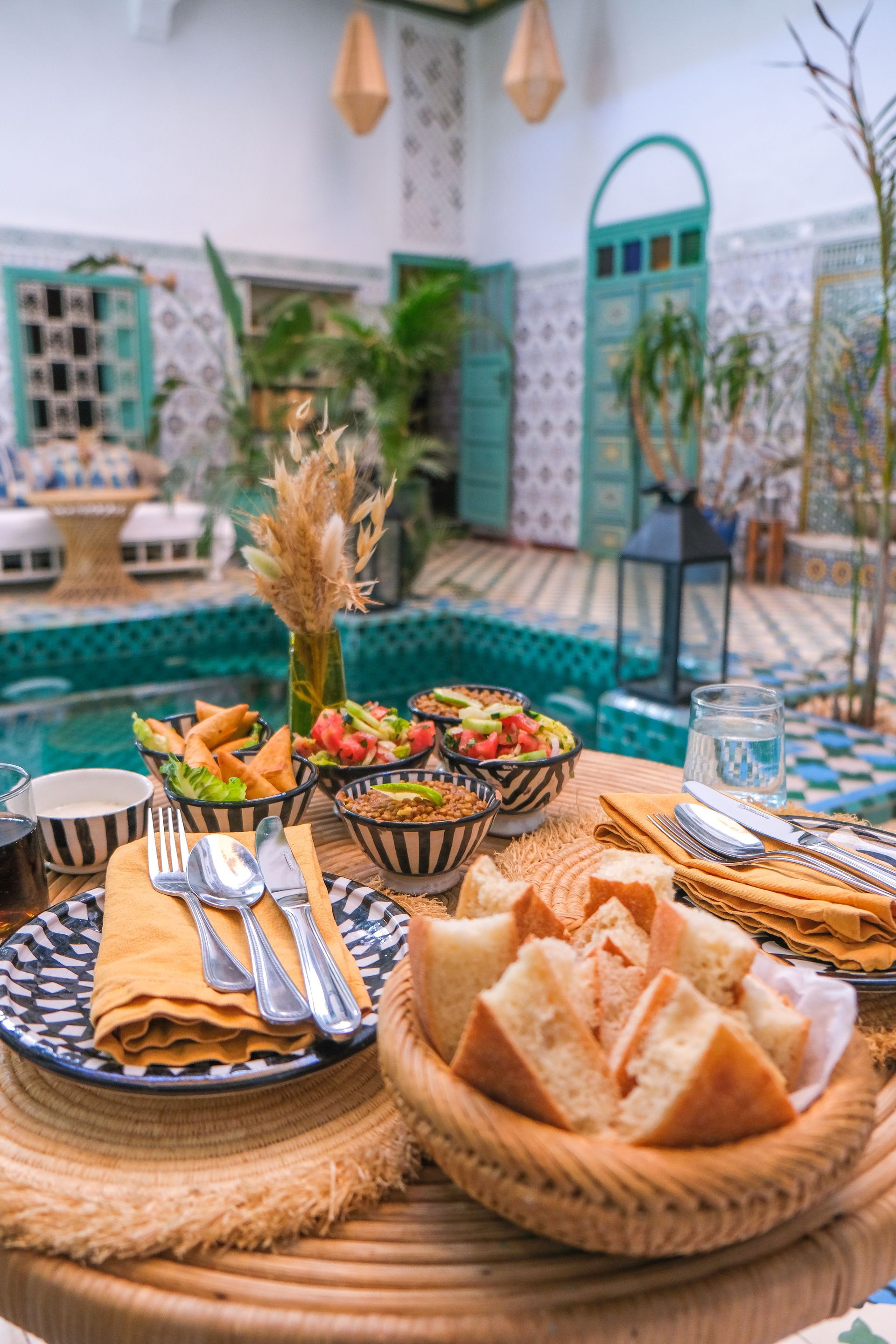 A table topped with plates of food and a basket of bread.