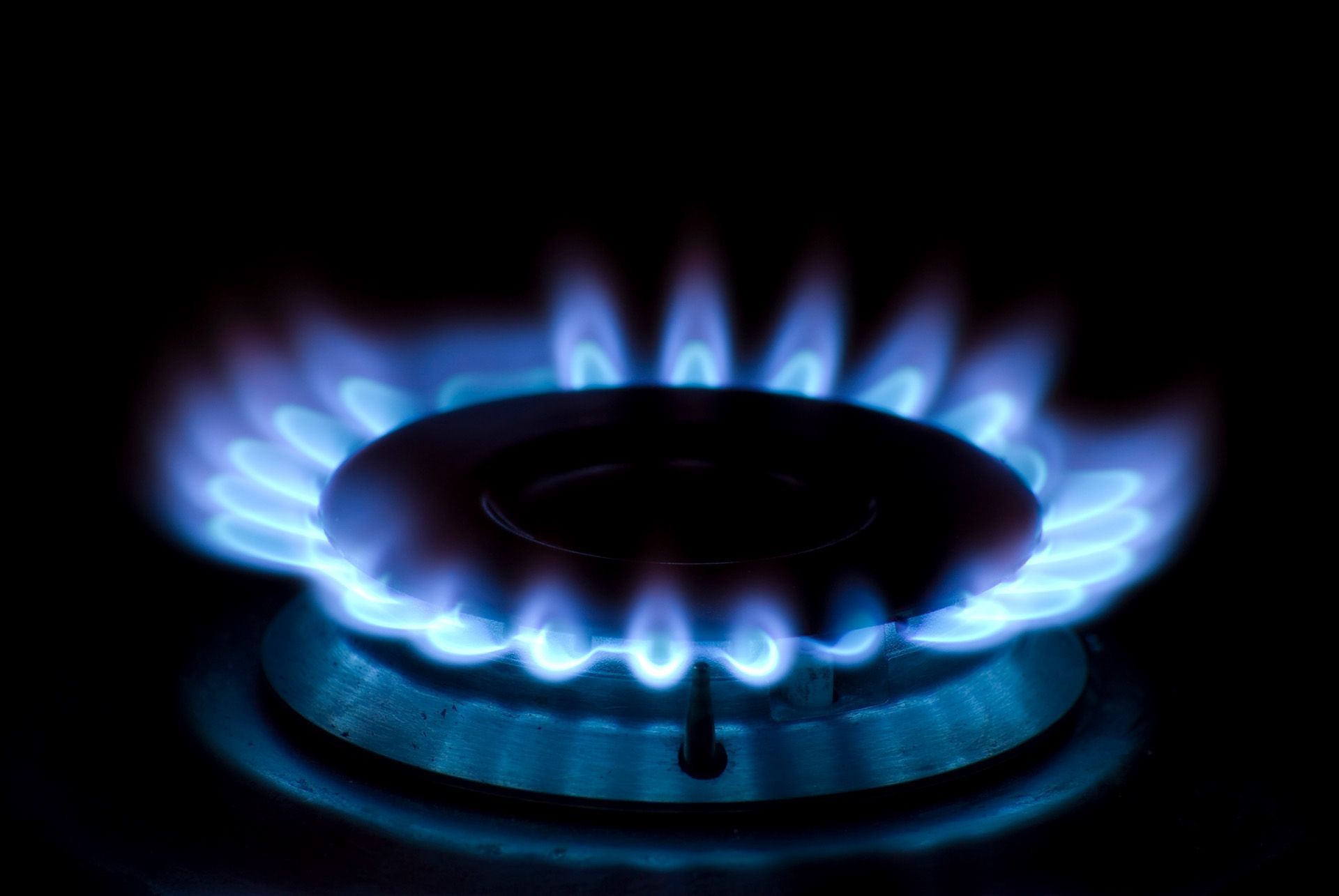 Blue natural gas stove burner flame glowing in dark kitchen for energy and cooking concept use. Blue natural gas stove burner flame glowing in dark kitchen for energy and cooking concept use.
