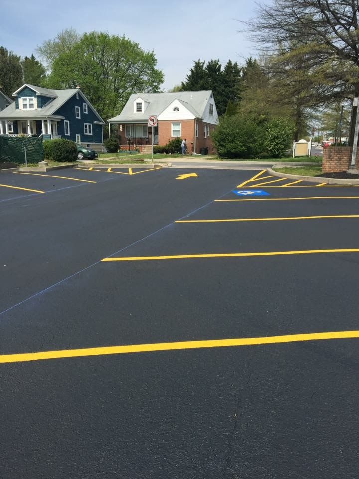 Empty parking lot with fresh yellow painted lines in front of houses and trees