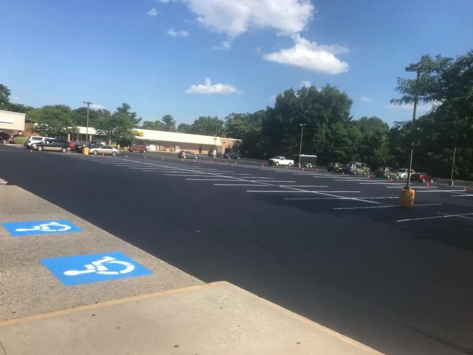 Mostly empty parking lot with accessible parking spaces on a sunny day