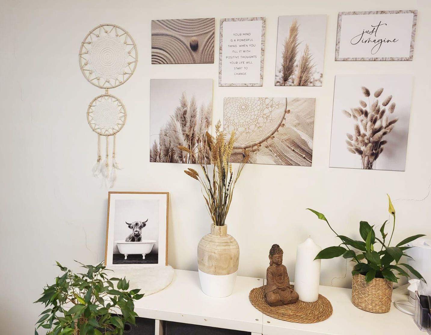 Ein Raum mit vielen Bildern an der Wand und einer Vase mit Blumen auf einem Tisch.