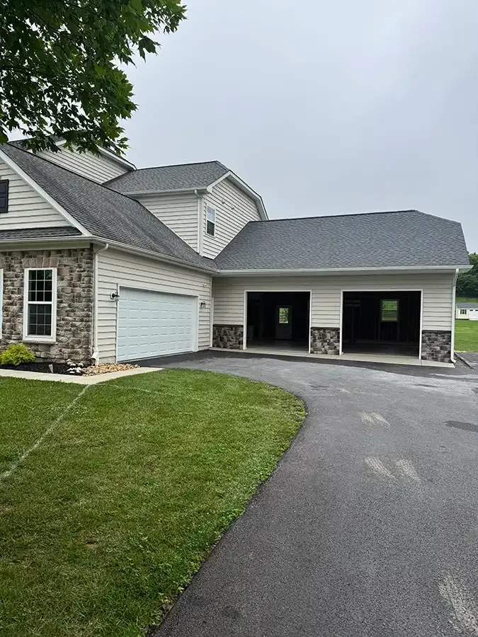 House with attached garage and long driveway on a cloudy day
