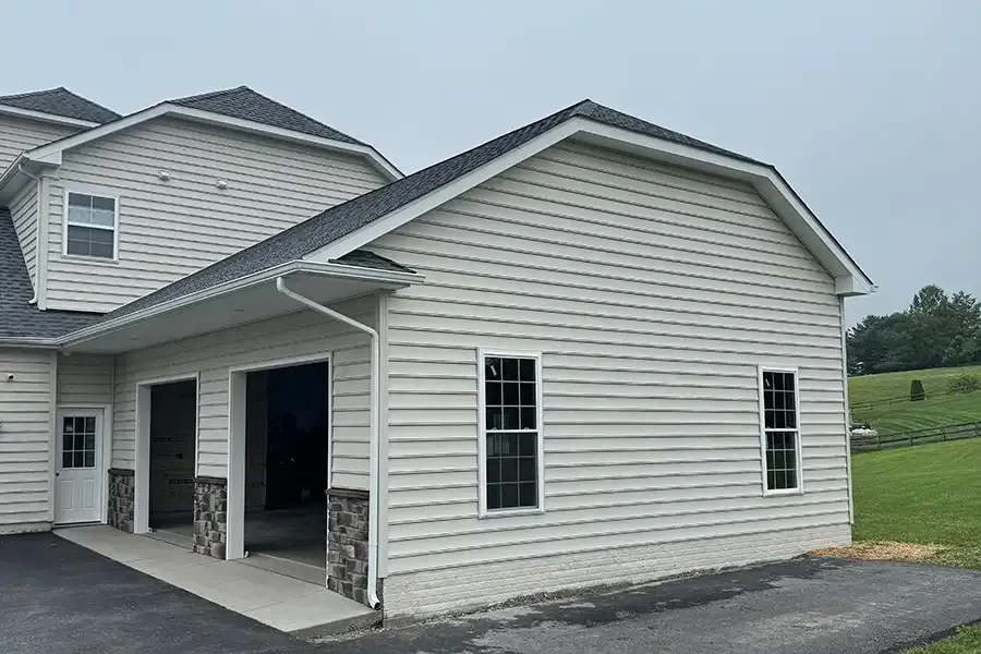 White house exterior with attached garage and stone accents on a cloudy day