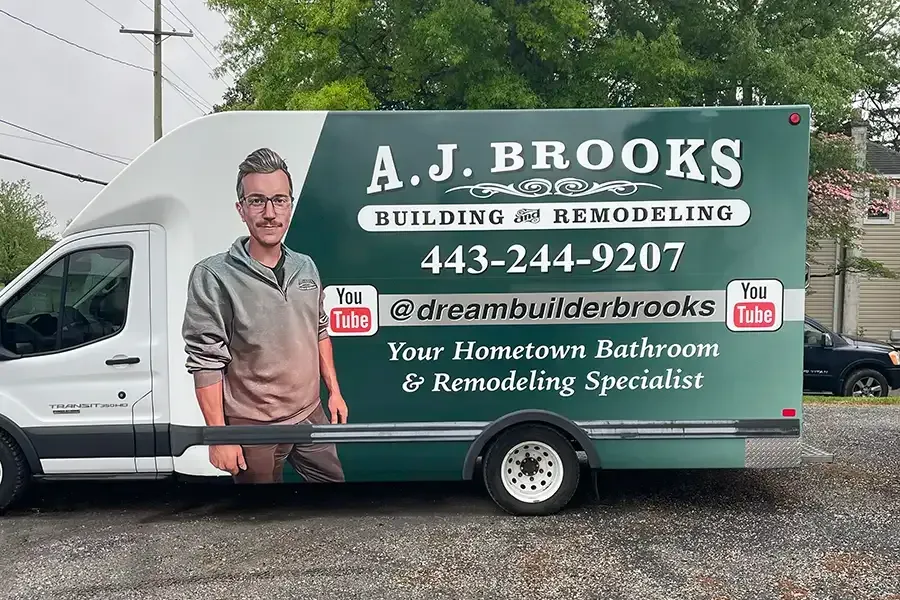 A.J. Brooks home remodeling van with company logo, phone number, and contractor portrait on the side